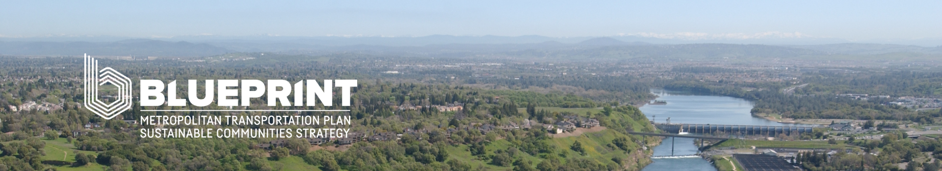 Ariel photo of Sacramento region with mountains, river, and houses in the background