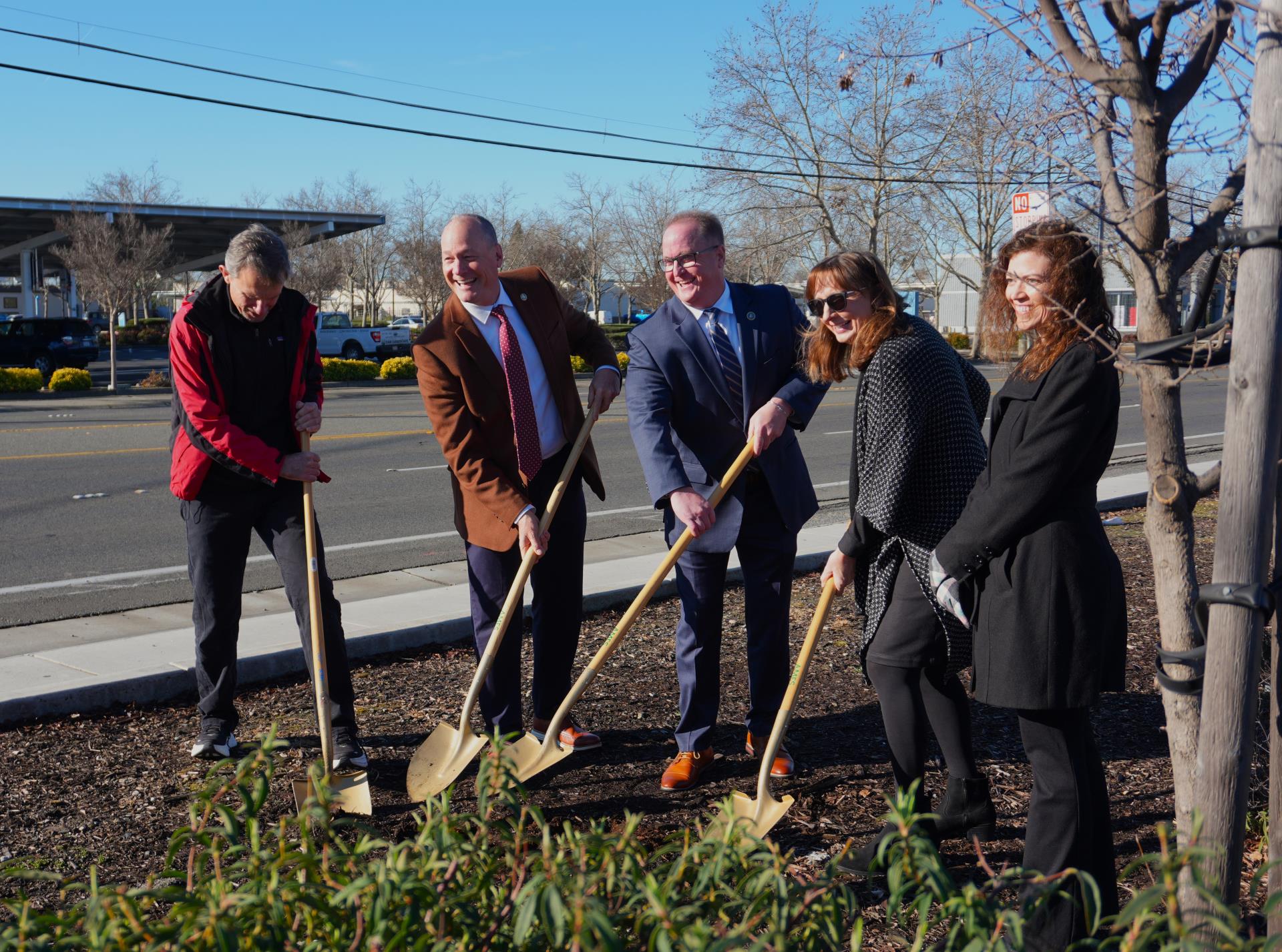 image of people smiling and posing with shovels