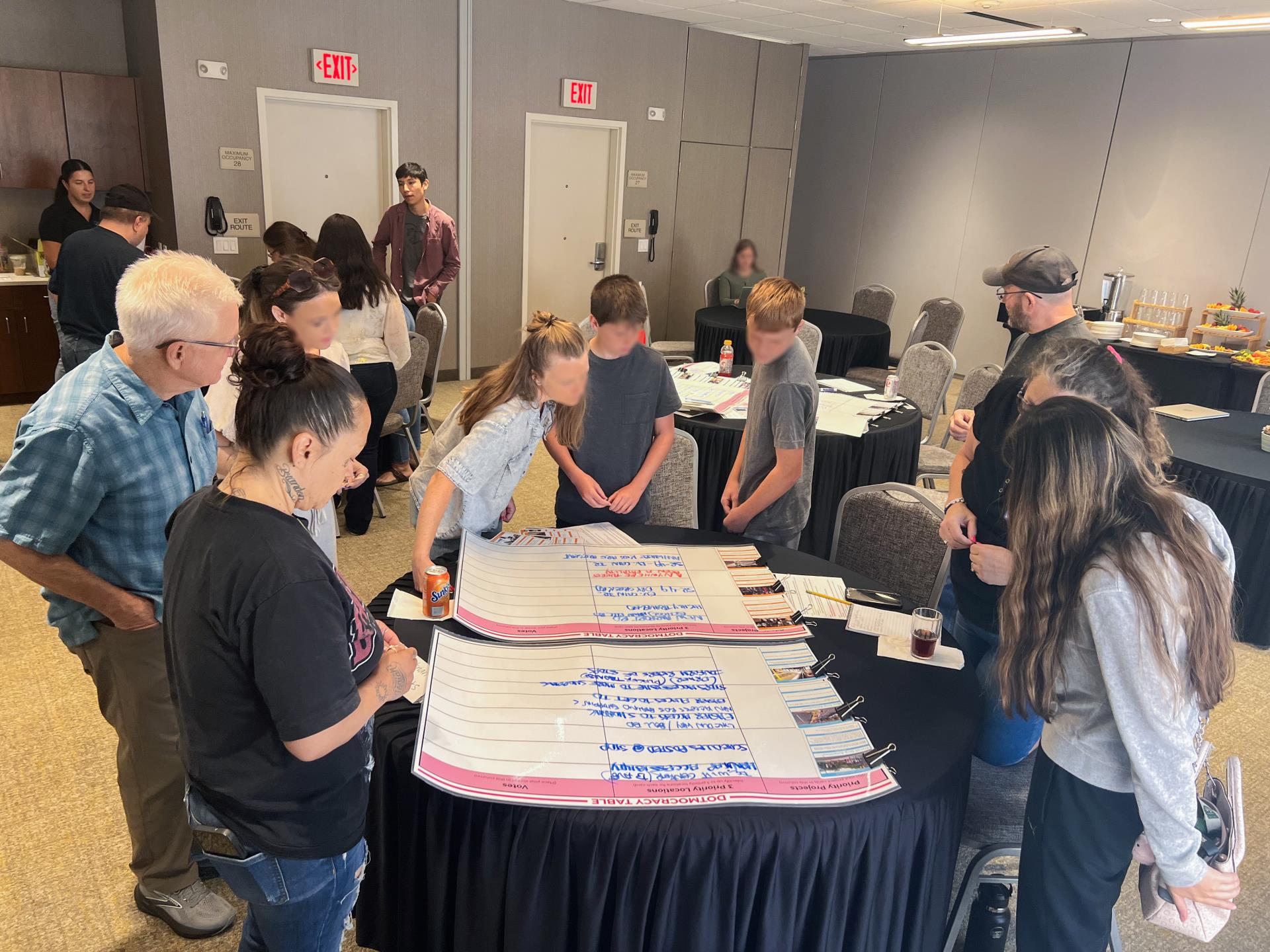group of people collaborating around a table looking over various papers