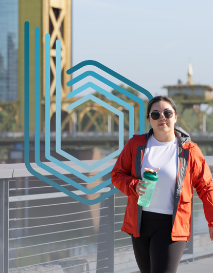 Woman walking on Sacramento river front with tower bridge behind and blueprint icon in background