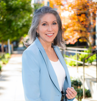 Becky Johnson posing for photo with trees in background